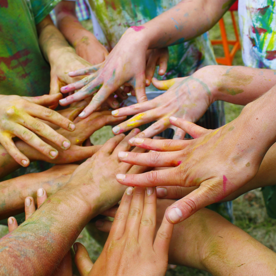 A group of people with their hands covered in paint.